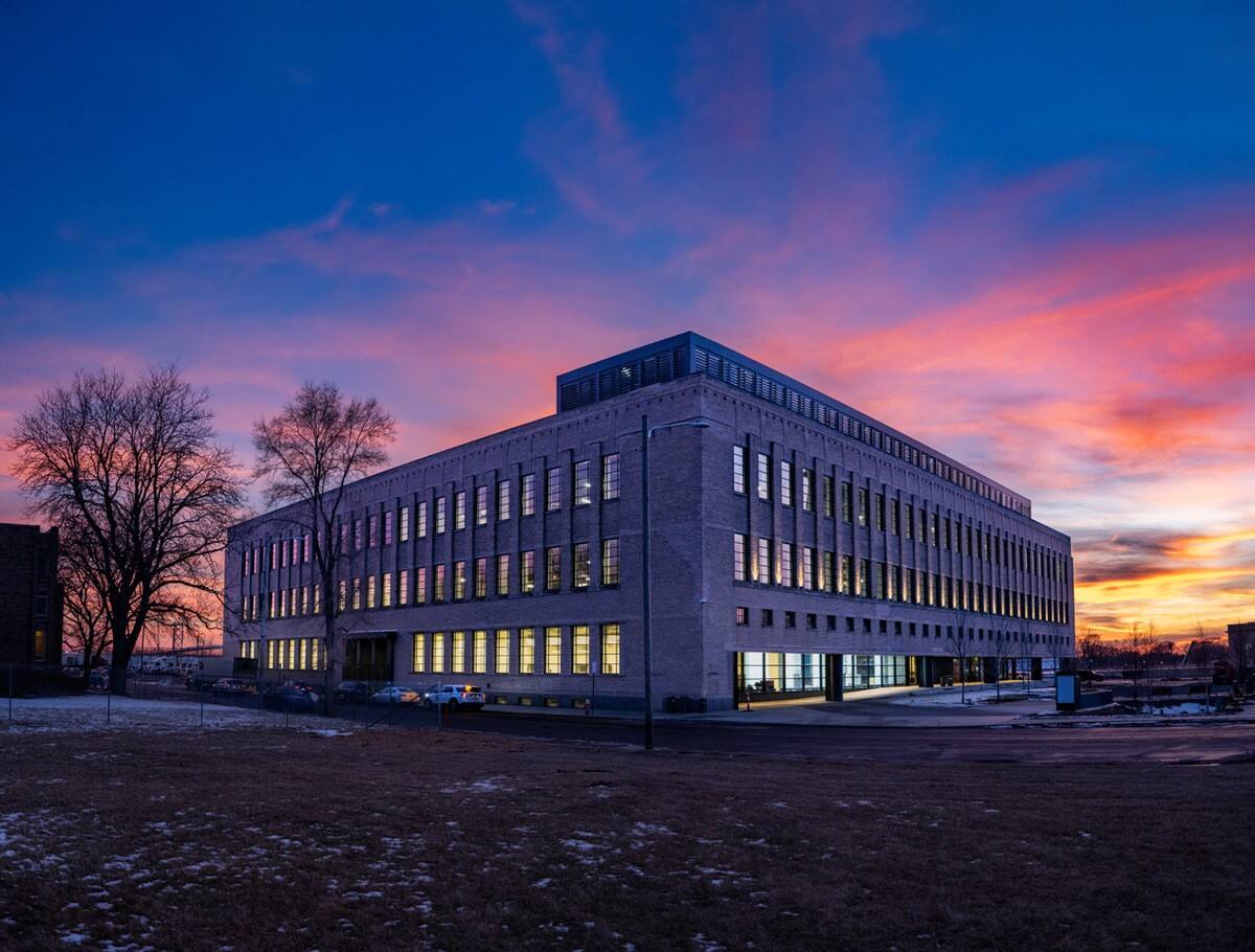 The exterior of the Book Depository Building under a sunset