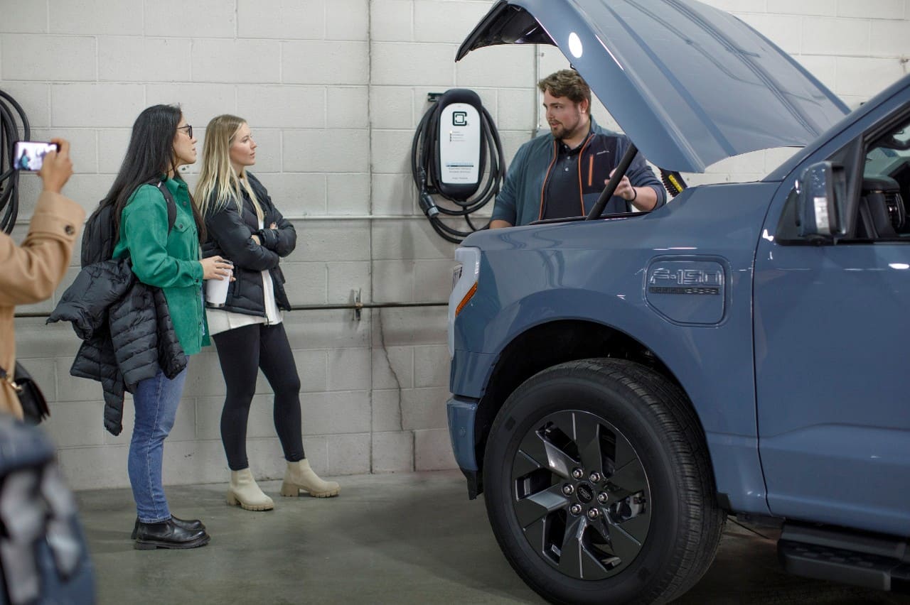 Finance analyst Wynter Mortz (second from left) gets an overview of how to charge the F-150 Lightning from F-150 Lightning Product Marketing Manager Will Marchand.