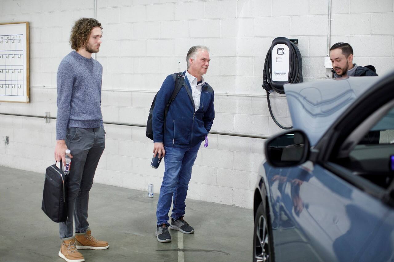 Global suspension designer Pat Bain (middle) gets an overview of the Mustang Mach-E from Assistant Brand Manager James Duszkiewicz (right).