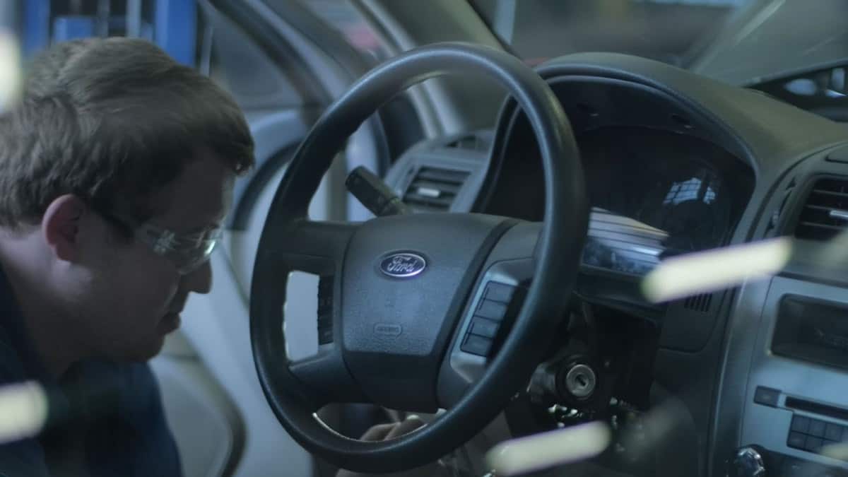 A technician closely inspects a steering wheel